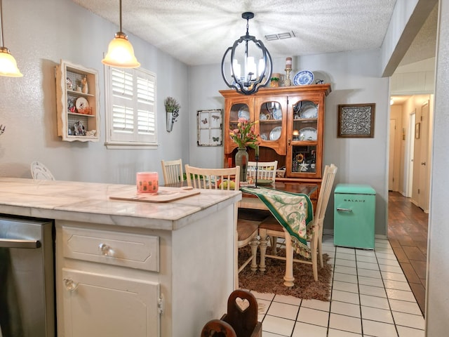 1847 Cody Pl, Odessa, TX 79762 - kitchen with a chandelier, light tile patterned floors, light countertops, a textured ceiling, and hanging light fixtures