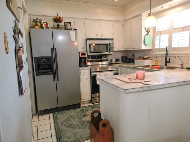 1847 Cody Pl, Odessa, TX 79762 - kitchen with stainless steel appliances, light countertops, light tile patterned floors, white cabinetry, and crown molding