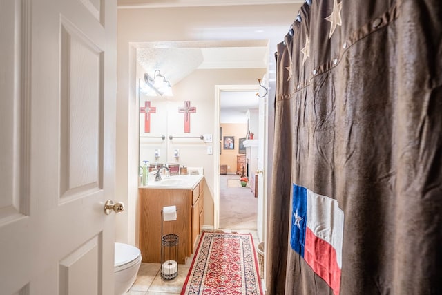 bathroom with tile patterned floors, crown molding, a textured ceiling, toilet, and vanity