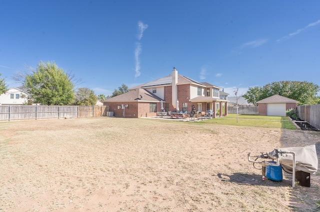 rear view of house with a patio and a lawn