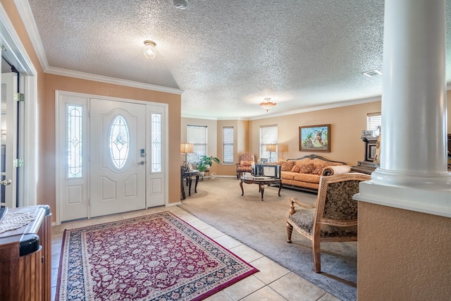 foyer entrance featuring a healthy amount of sunlight, light tile patterned flooring, ornate columns, and a textured ceiling