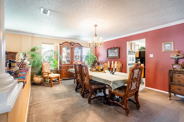 carpeted dining area featuring ornamental molding, a textured ceiling, and a chandelier