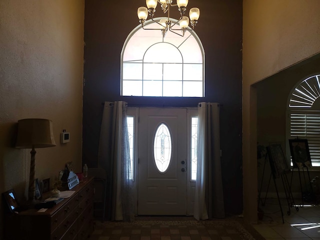entryway featuring an inviting chandelier and a high ceiling