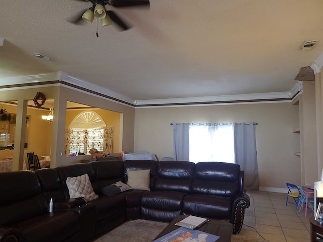 living room with a ceiling fan, baseboards, light tile patterned floors, visible vents, and crown molding