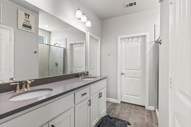 3102 Mearns Ct, Midland, TX 79705 - bathroom with a stall shower, double vanity, and wood finished floors