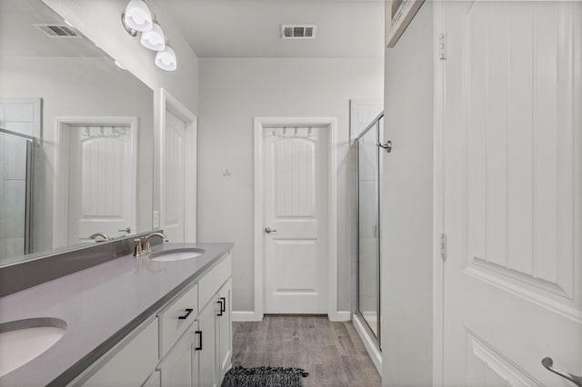 3102 Mearns Ct, Midland, TX 79705 - bathroom featuring a stall shower, double vanity, and wood finished floors