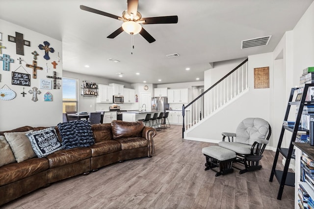 3102 Mearns Ct, Midland, TX 79705 - living room featuring stairs, wood finished floors, ceiling fan, and recessed lighting