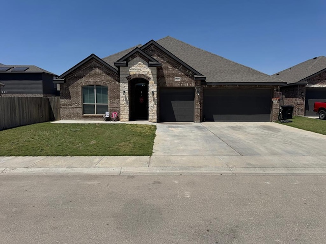 7001 La Escalera Ct, Odessa, TX 79765 - french country inspired facade featuring brick siding, a garage, concrete driveway, and roof with shingles