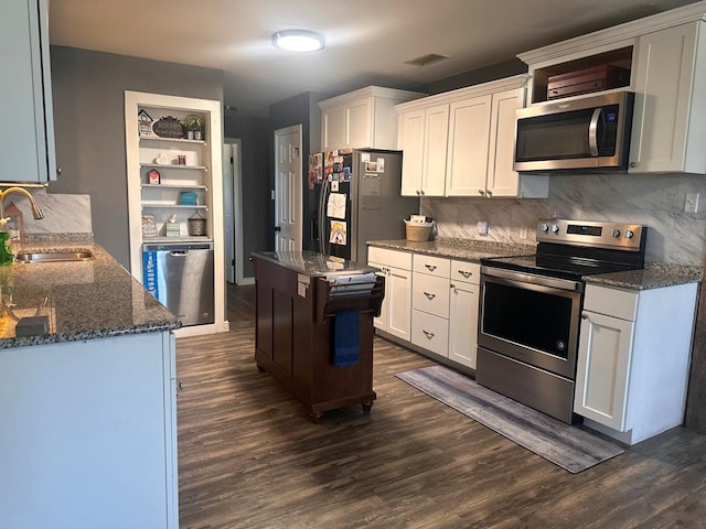 301 SW 11th St, Andrews, TX 79714 - kitchen featuring stainless steel appliances, dark wood-style floors, white cabinetry, and tasteful backsplash