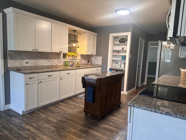 301 SW 11th St, Andrews, TX 79714 - kitchen featuring fridge, white cabinets, tasteful backsplash, and dark wood-type flooring