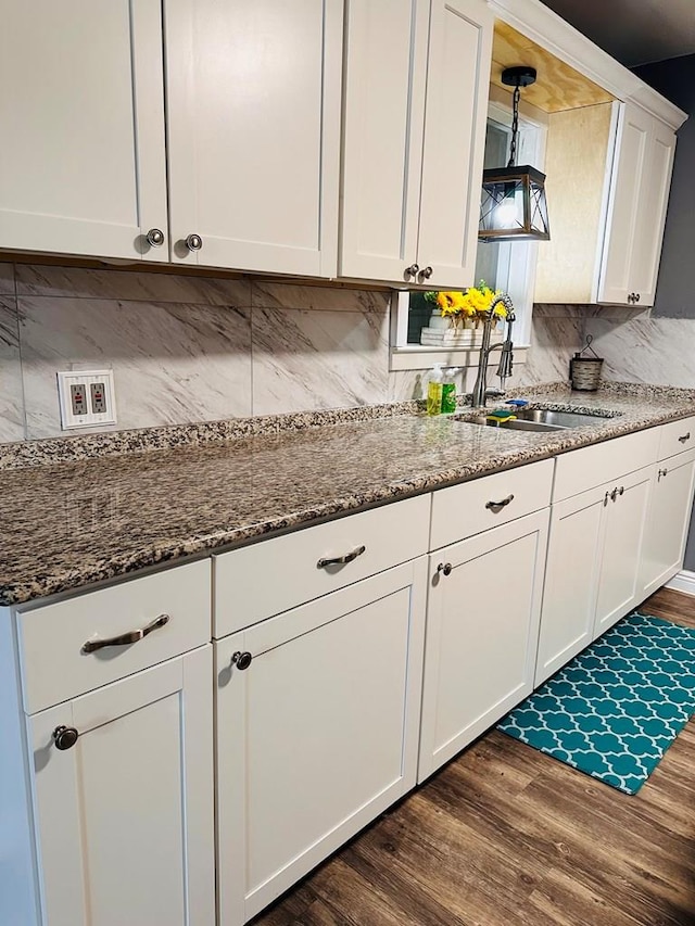301 SW 11th St, Andrews, TX 79714 - kitchen with dark wood-type flooring, white cabinetry, decorative backsplash, and dark stone counters