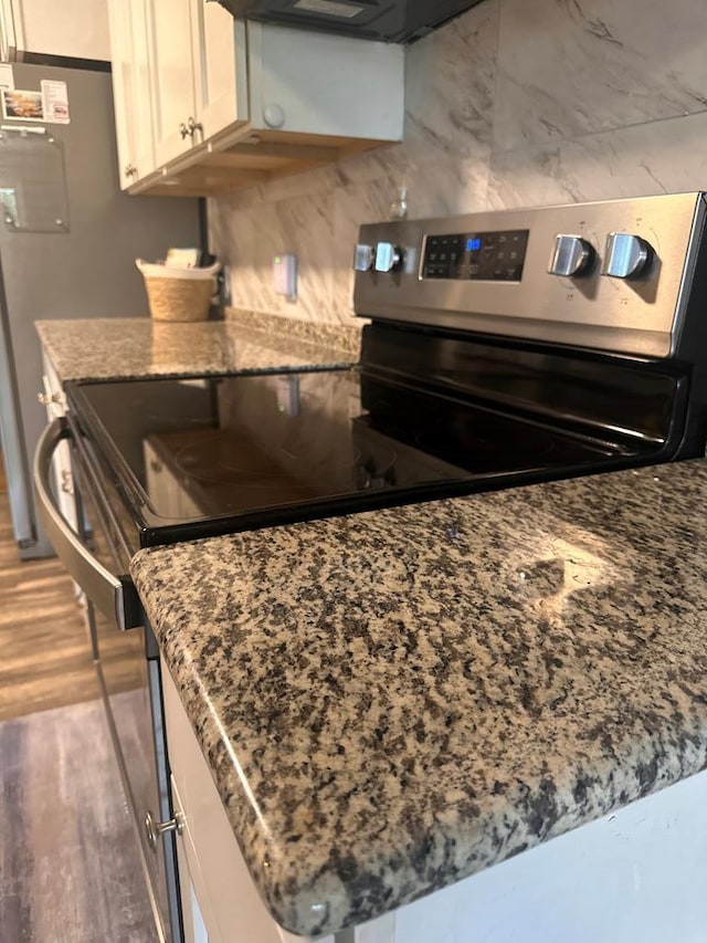 301 SW 11th St, Andrews, TX 79714 - kitchen with stainless steel electric range, light wood-style floors, stone counters, and white cabinetry