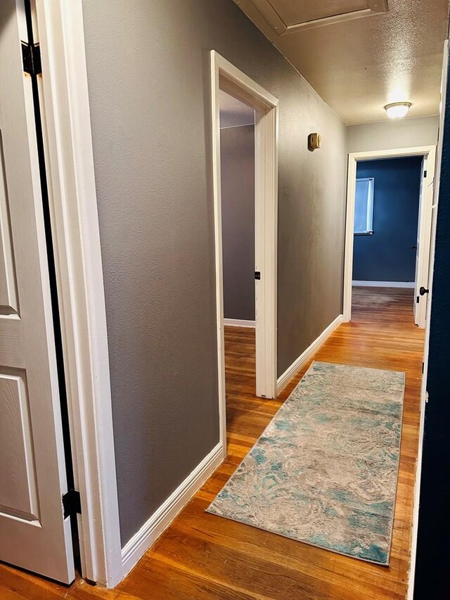 301 SW 11th St, Andrews, TX 79714 - hallway featuring wood finished floors and a textured ceiling