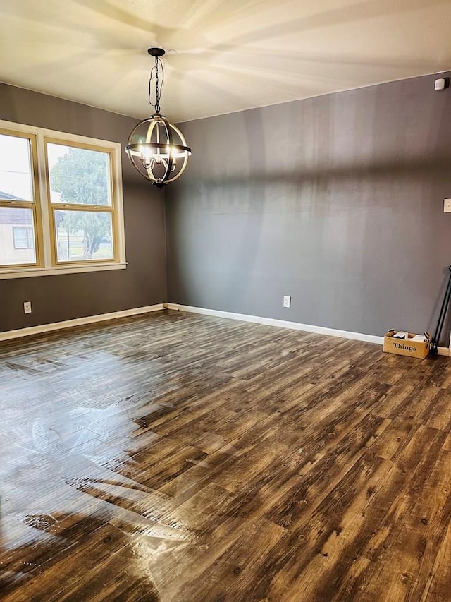 301 SW 11th St, Andrews, TX 79714 - unfurnished room with dark wood-type flooring and a chandelier