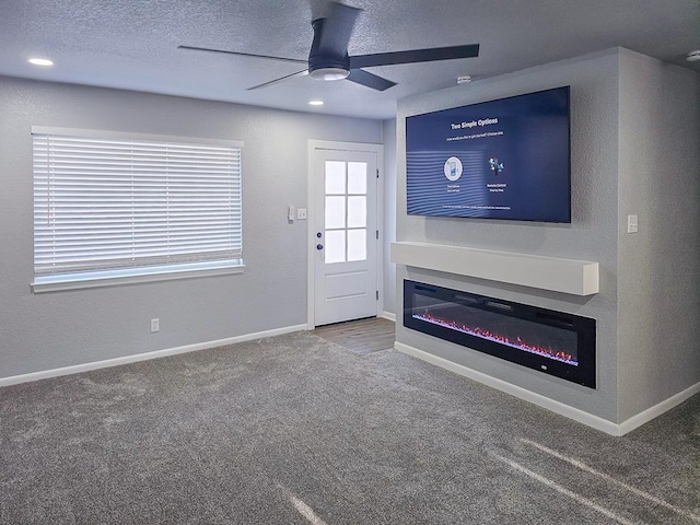 311 SW 9th St, Andrews, TX 79714 - unfurnished living room featuring carpet flooring, ceiling fan, a textured ceiling, and baseboards