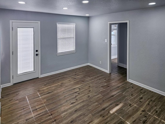 311 SW 9th St, Andrews, TX 79714 - unfurnished room with dark wood-type flooring, recessed lighting, baseboards, a textured ceiling, and a textured wall