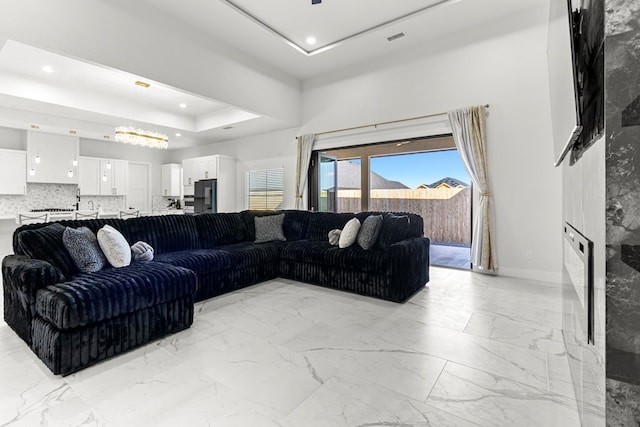 8652 Fiesta Ct, Odessa, TX 79765 - living room with light marble finish flooring, a raised ceiling, and recessed lighting