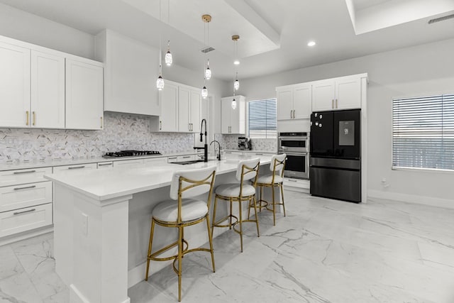8652 Fiesta Ct, Odessa, TX 79765 - kitchen with freestanding refrigerator, double oven, light marble finish floors, a center island with sink, and backsplash
