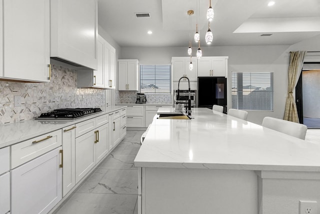 8652 Fiesta Ct, Odessa, TX 79765 - kitchen with light marble finish flooring, fridge, white cabinetry, tasteful backsplash, and recessed lighting