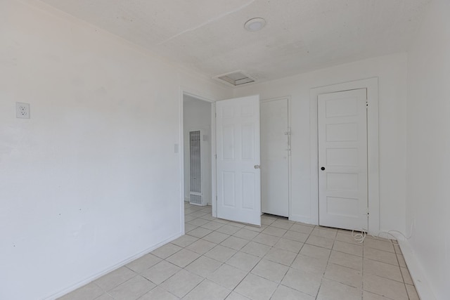900 N Dotsy Ave, Odessa, TX 79763 - unfurnished room featuring a heating unit, attic access, and light tile patterned floors