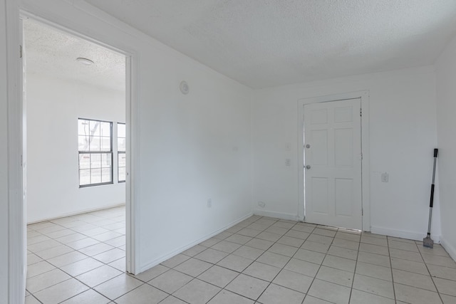 900 N Dotsy Ave, Odessa, TX 79763 - spare room featuring a textured ceiling and light tile patterned floors