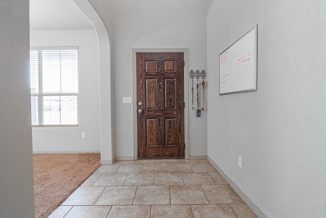 1506 San Miguel Ct, Midland, TX 79705 - entryway with plenty of natural light, light colored carpet, baseboards, and arched walkways