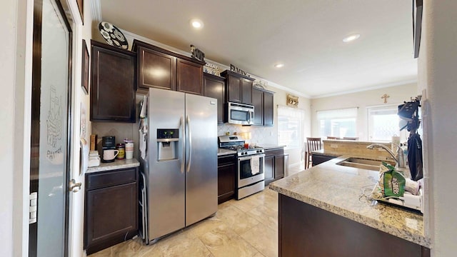 kitchen featuring sink, decorative backsplash, ornamental molding, dark brown cabinetry, and stainless steel appliances