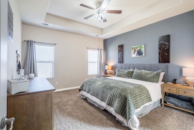 bedroom featuring a tray ceiling, ceiling fan, and carpet floors