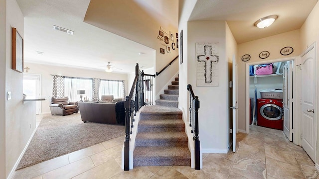 stairway featuring washer / dryer, carpet floors, and ceiling fan