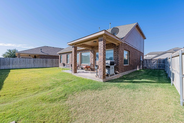 rear view of property featuring a yard and a patio