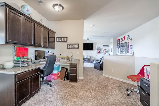 home office with light carpet, built in desk, and ceiling fan