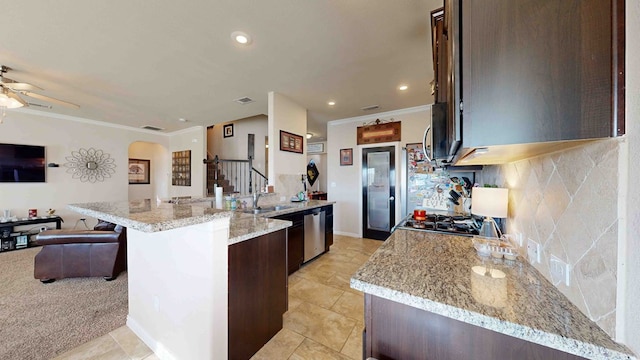 kitchen featuring light stone counters, ornamental molding, dark brown cabinets, stainless steel appliances, and a kitchen island with sink