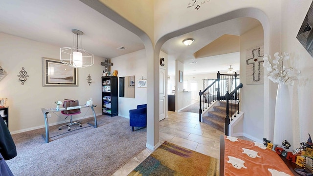 carpeted entrance foyer featuring a notable chandelier