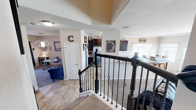 corridor featuring a textured ceiling and ornamental molding