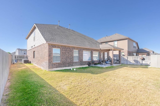 rear view of property featuring a patio, central air condition unit, and a lawn