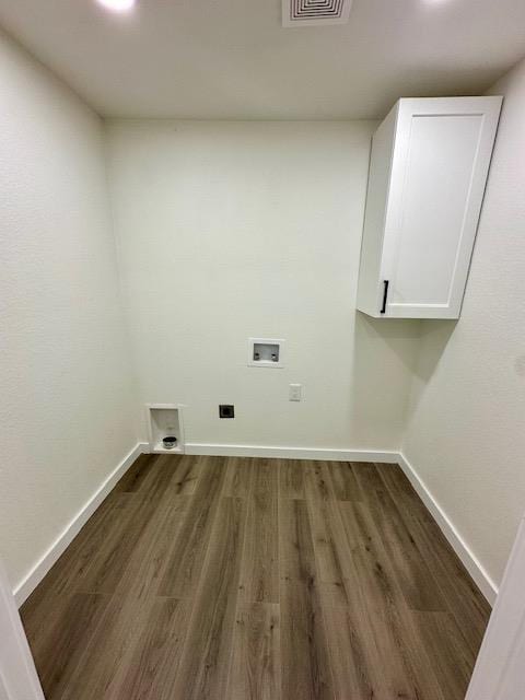 washroom with hookup for a washing machine, cabinets, and dark hardwood / wood-style floors