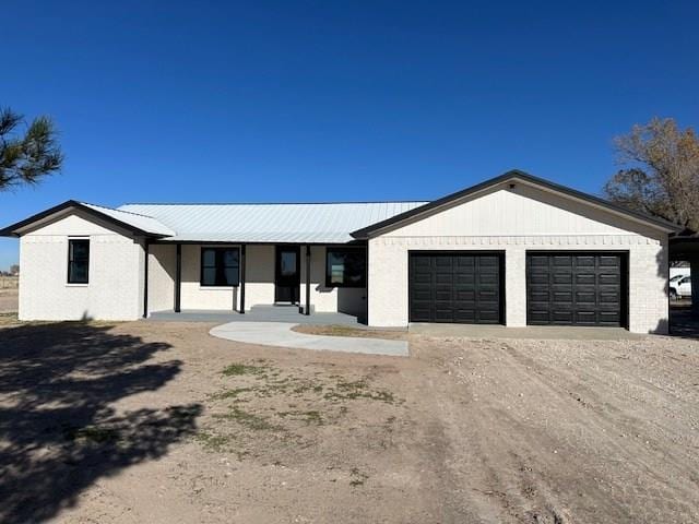 single story home with covered porch and a garage