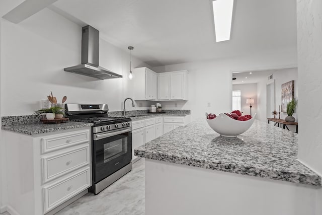 kitchen with gas stove, wall chimney range hood, light marble finish flooring, white cabinets, and light stone counters