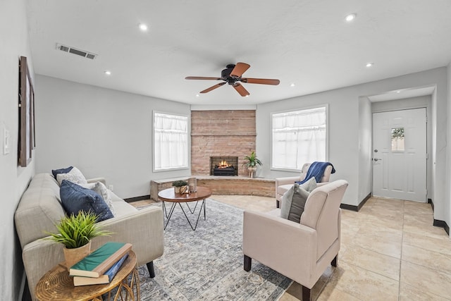 living room featuring recessed lighting, plenty of natural light, a large fireplace, and a ceiling fan