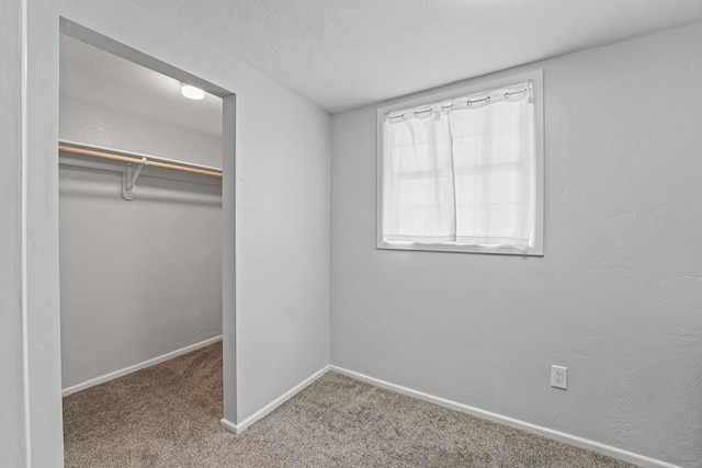 unfurnished bedroom with carpet flooring, baseboards, and a closet