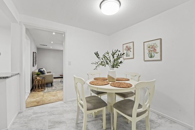 dining area with baseboards and light marble finish flooring