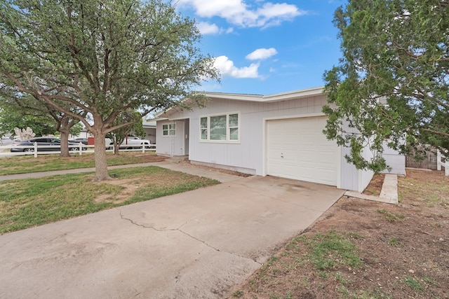 view of front of home with an attached garage, driveway, and fence