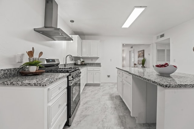 kitchen with stainless steel gas range, range hood, light stone counters, white cabinetry, and a sink