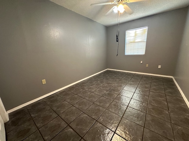 902 W 39th St, Odessa, TX 79764 - unfurnished room with a textured ceiling, ceiling fan, and dark tile patterned floors