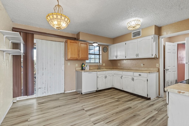 kitchen with visible vents, white cabinetry, light countertops, dishwasher, and decorative light fixtures