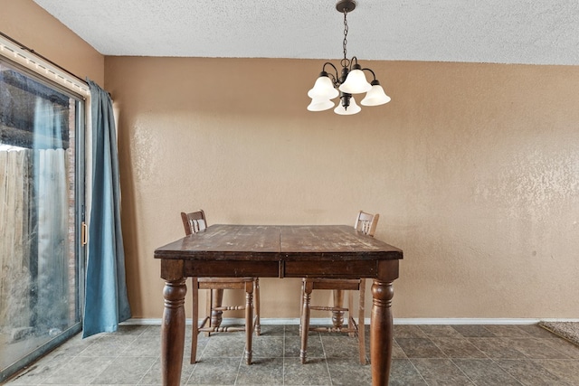 unfurnished dining area featuring baseboards, a chandelier, a textured ceiling, and a textured wall