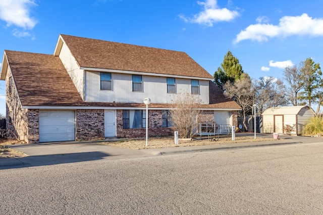 view of front of house with a garage, a storage shed, a shingled roof, brick siding, and driveway