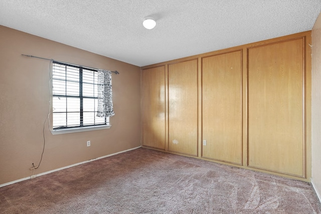 unfurnished room with a textured ceiling and light colored carpet