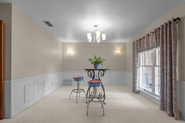 9408 Cromwell Ter, Odessa, TX 79764 - unfurnished dining area with a notable chandelier, wainscoting, visible vents, and carpet
