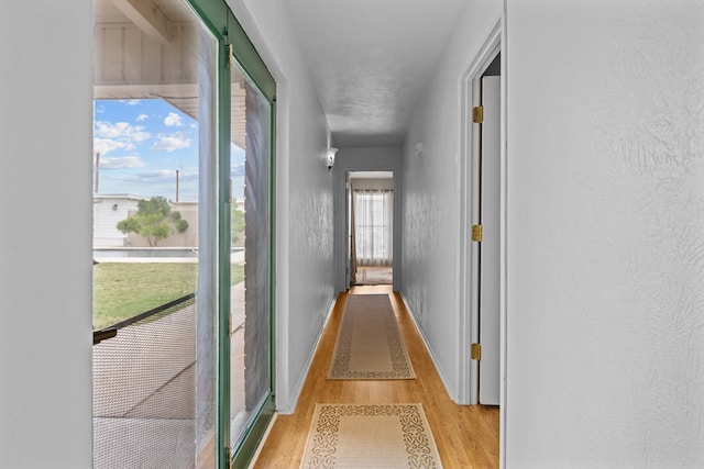 9408 Cromwell Ter, Odessa, TX 79764 - hallway with light wood-type flooring, baseboards, and a textured wall